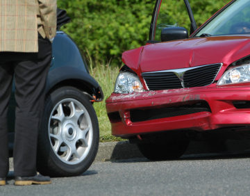 person standing at car after care accident